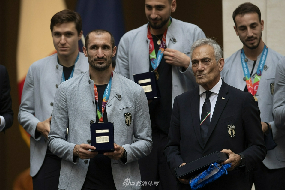 主帅曼奇尼与球员们在花车上共同举起双臂，纵情欢呼，背景是罗马古老的街道与现代的庆祝人群，时空在这一刻因足球而完美交融。