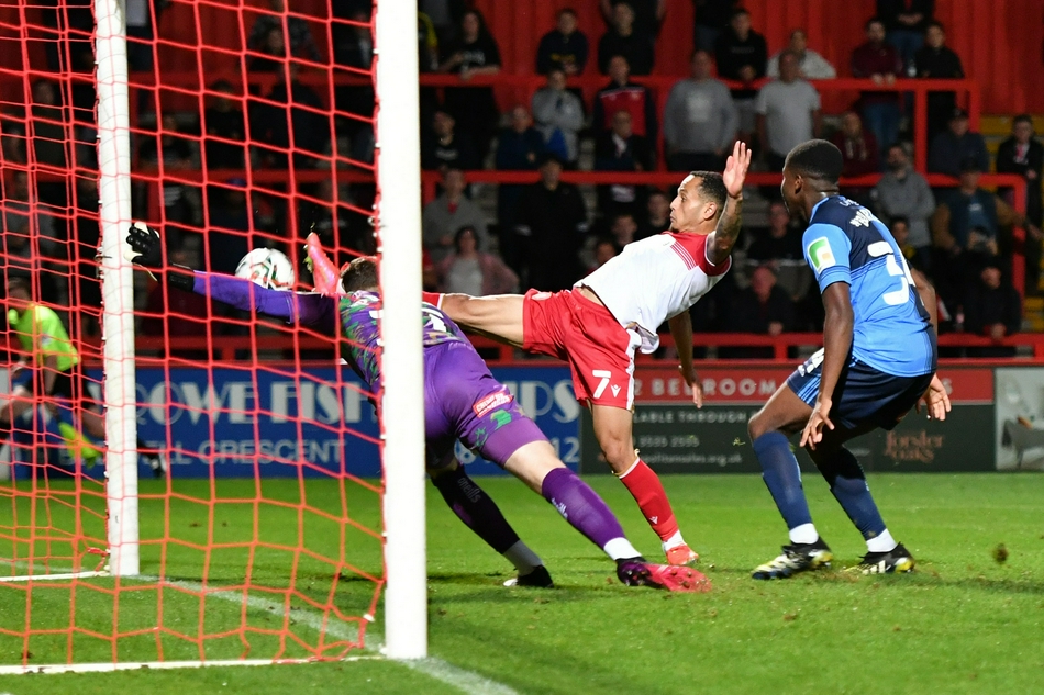 斯蒂夫尼奇球员们紧紧拥抱在一起，庆祝杰米·雷德的进球，他们脸上的表情充满狂喜和坚定，此刻他们看到了逆转晋级的一线曙光。