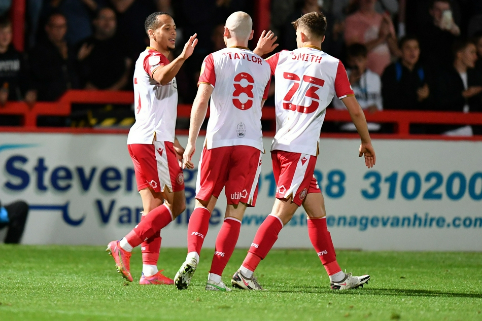 韦康比流浪者的新援泰伊·德巴尔在进球后双手指天，激动地奔跑庆祝，他的队友们从四面八方赶来，向这位上演完美处子秀的英雄表示祝贺。