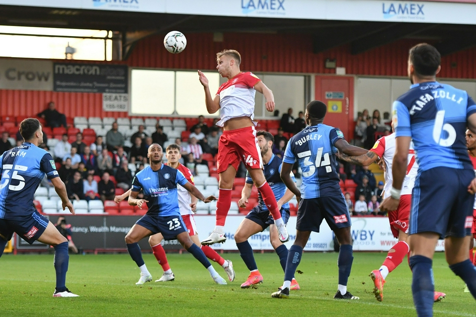 斯蒂夫尼奇前锋埃利奥特·利斯特在进球后激情滑跪，他身后的看台上，主队球迷们挥舞着围巾，爆发出雷鸣般的欢呼声，整个球场为之沸腾。