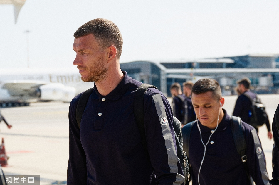 几名国际米兰球员在登车前短暂驻足，回头望向送行的球迷或媒体镜头，脸上露出自信的微笑。