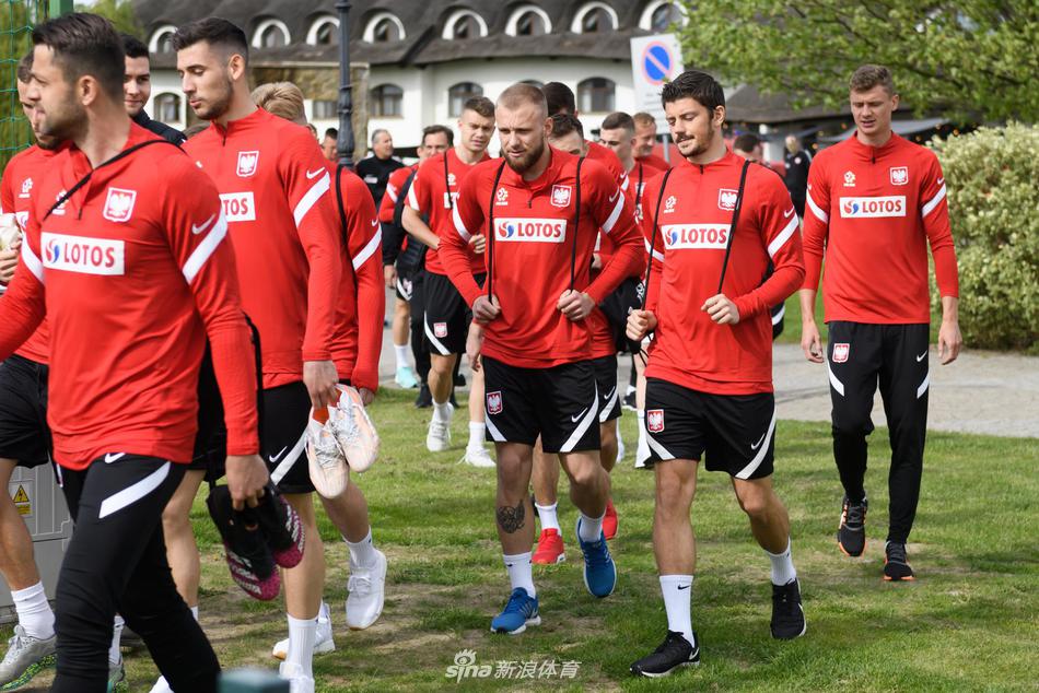 波兰球员们围成一个紧密的圆圈进行抢圈热身，展现出强大的团队凝聚力，每个人的脸上都写满了对胜利的渴望。