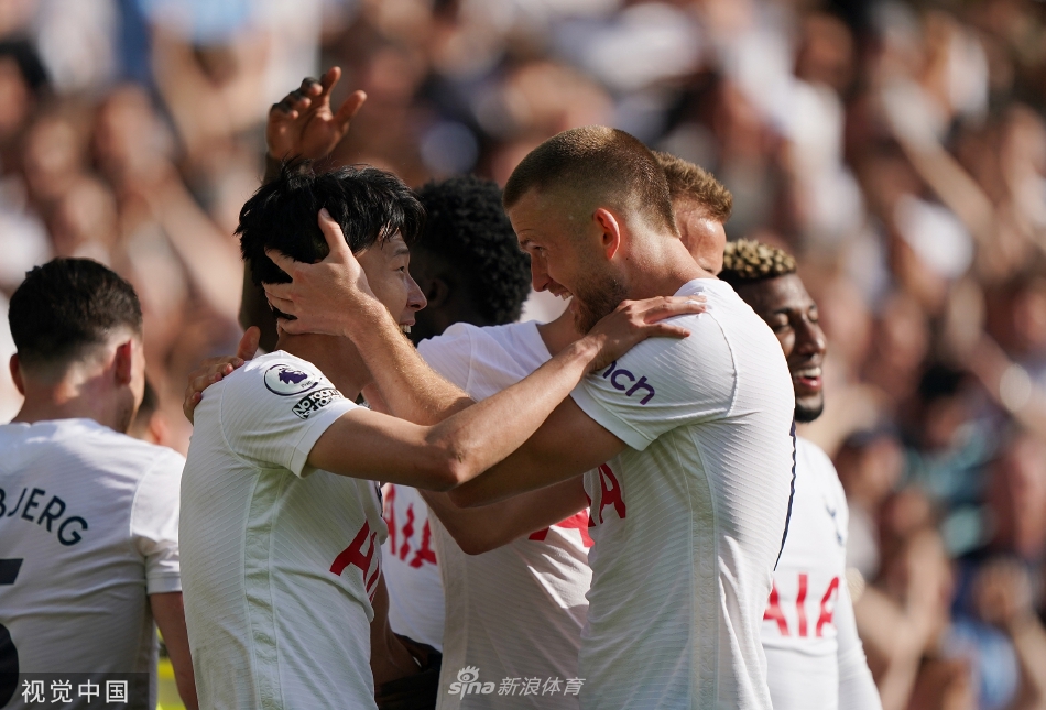 热刺全队赛后肩搭肩围成一圈激情庆祝，背景是正在退场的主队球迷看台