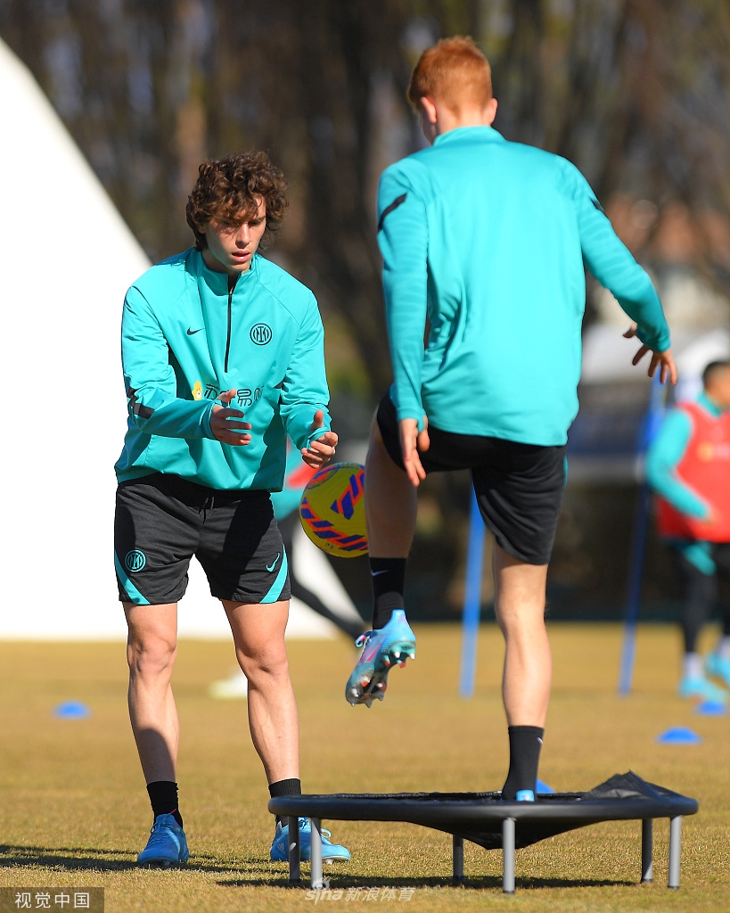 训练结束后，比达尔与队友边走边交流，夕阳将他们的身影拉长