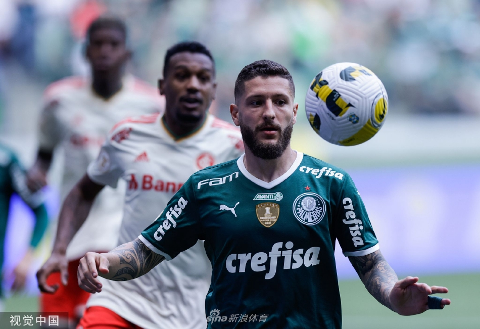 夜幕下的安联公园球场灯光璀璨，看台上绿色旗帜舞动犹如澎湃海洋，预示着大战一触即发