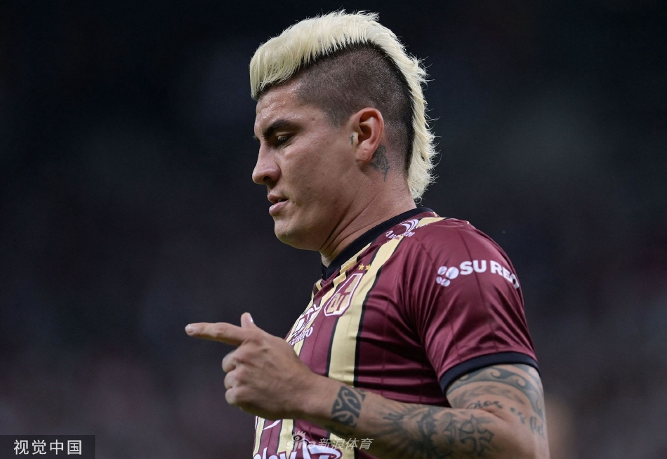 米内罗竞技球员庆祝进球瞬间，多名队员兴奋地拥抱在一起，背景中可以看到看台上无数举起的手臂和飞扬的旗帜