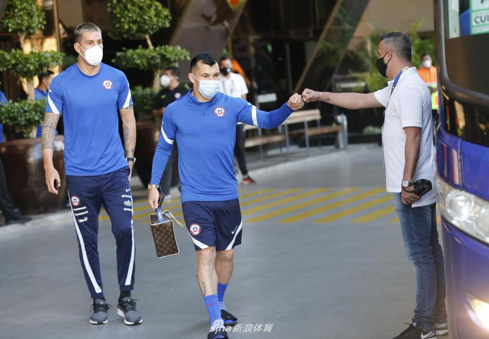 在这张充满故事感的照片中，智利球员们三两成群，拖着行李行走在酒店的廊道间。他们的步伐坚定而有力，踏出的每一步都仿佛敲击在战鼓之上。有人低头沉思，有人抬头望向远方，还有人在低声交流着战术。这不仅仅是一次简单的入住登记，更像是战士们在进入角斗场前，最后一次整理自己的铠甲与剑刃。红色的队服如同一团团跳动的火焰，在戈亚纳的午后显得格外醒目，它们即将点燃整个美洲杯的夏日激情。