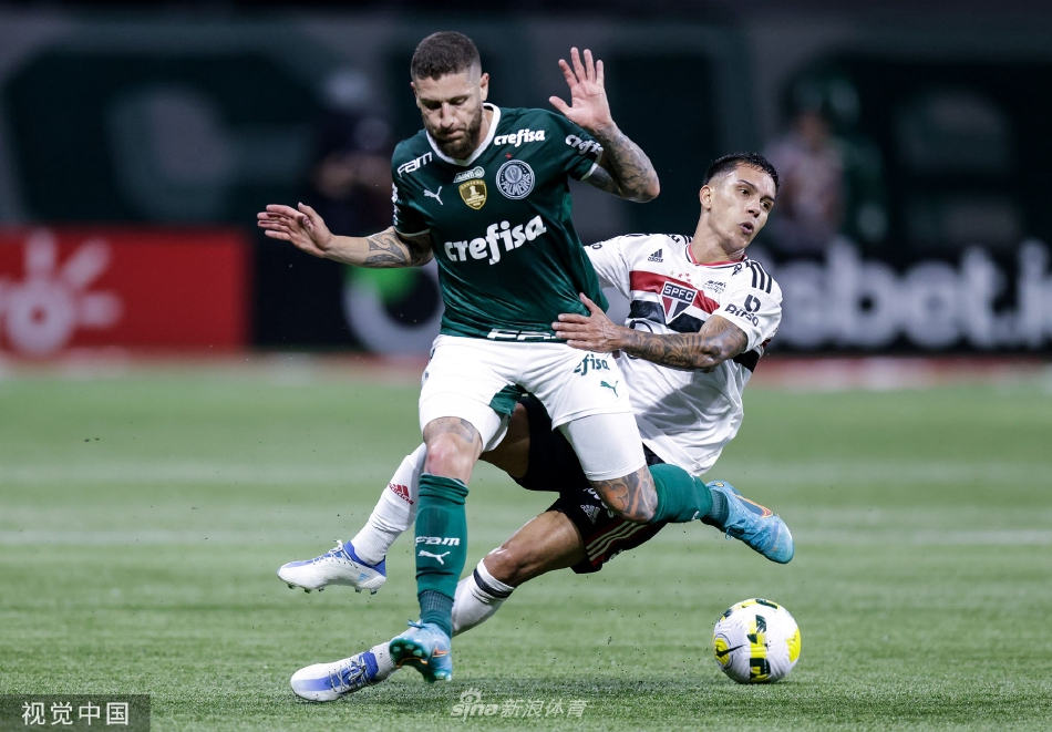 点球大战决胜时刻，一名球员背对球门低头祈祷，身影在巨大的球场灯光下显得无比紧张而孤独。