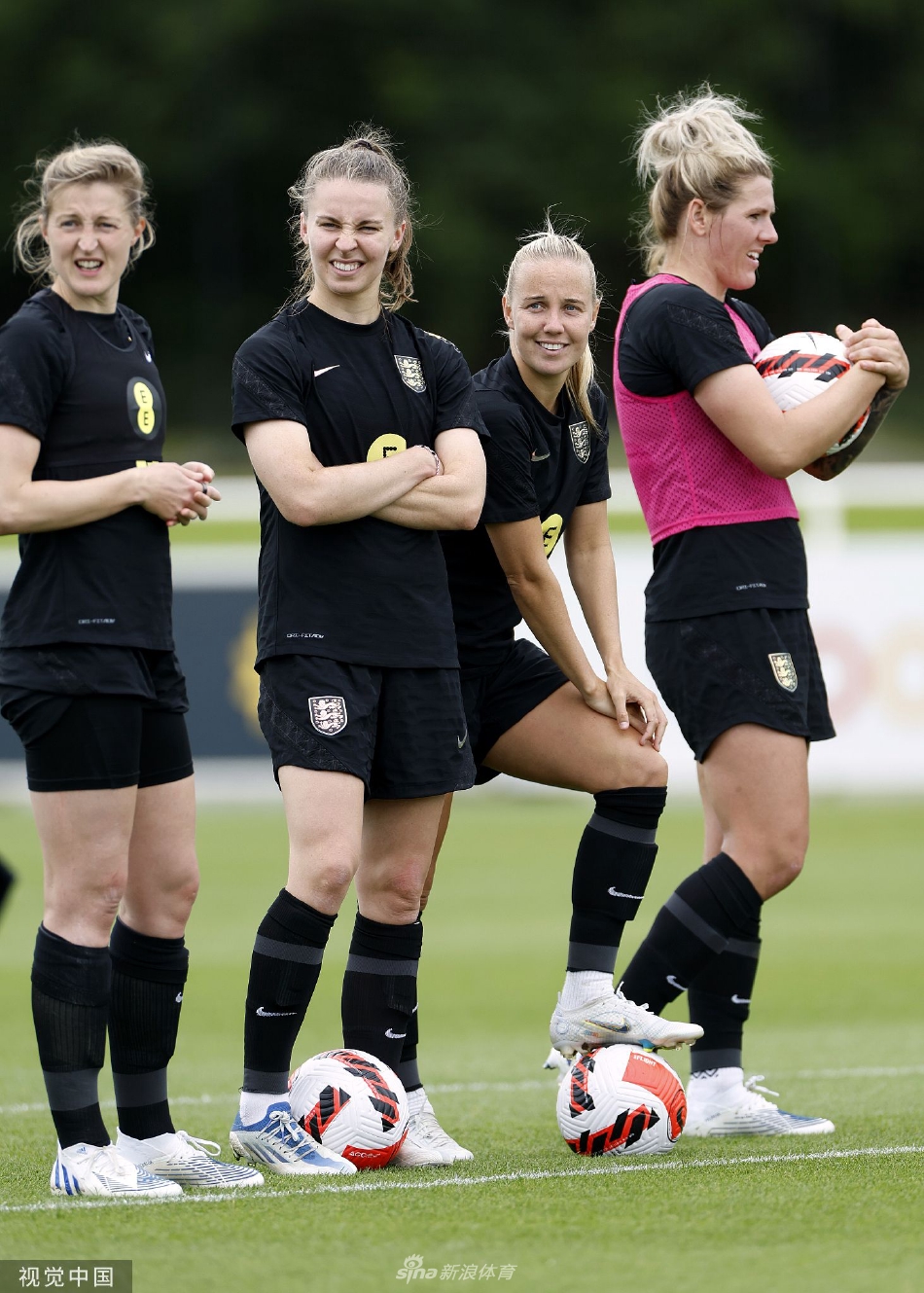 中场球员在草地上进行拉伸与恢复性训练，夕阳为训练场披上金色，氛围宁静而专注。