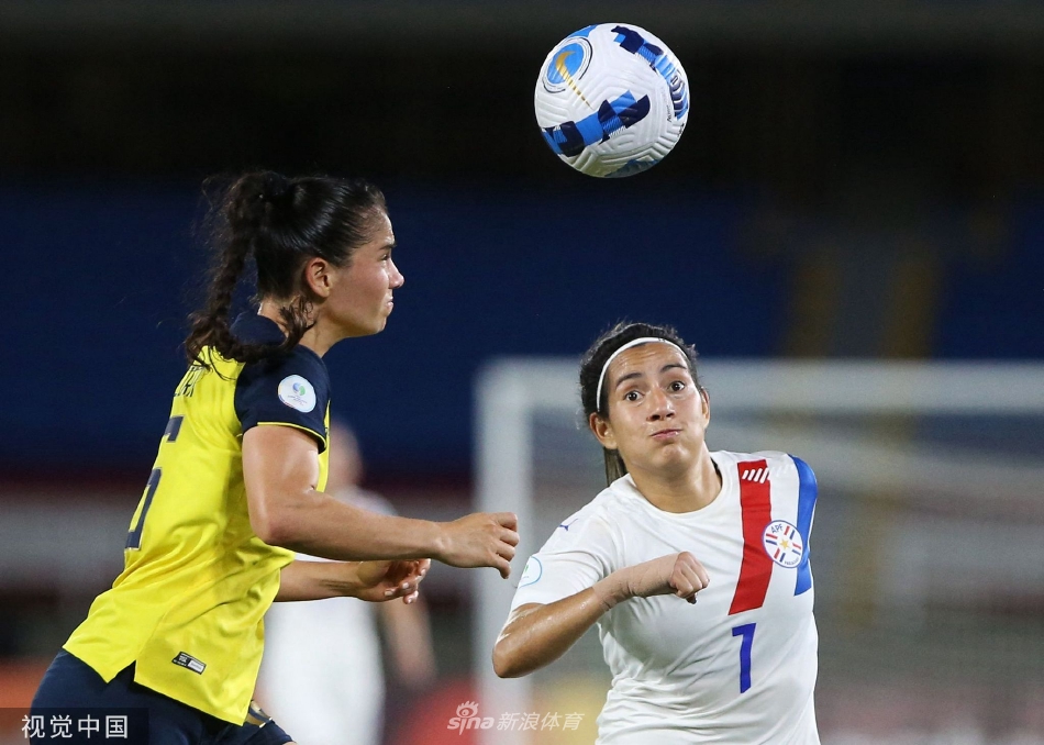 双方球员在中场展开高空球激烈争顶，她们同时跃起，身影在阳光下交错，展现了女足比赛不输男足的力量与勇气。