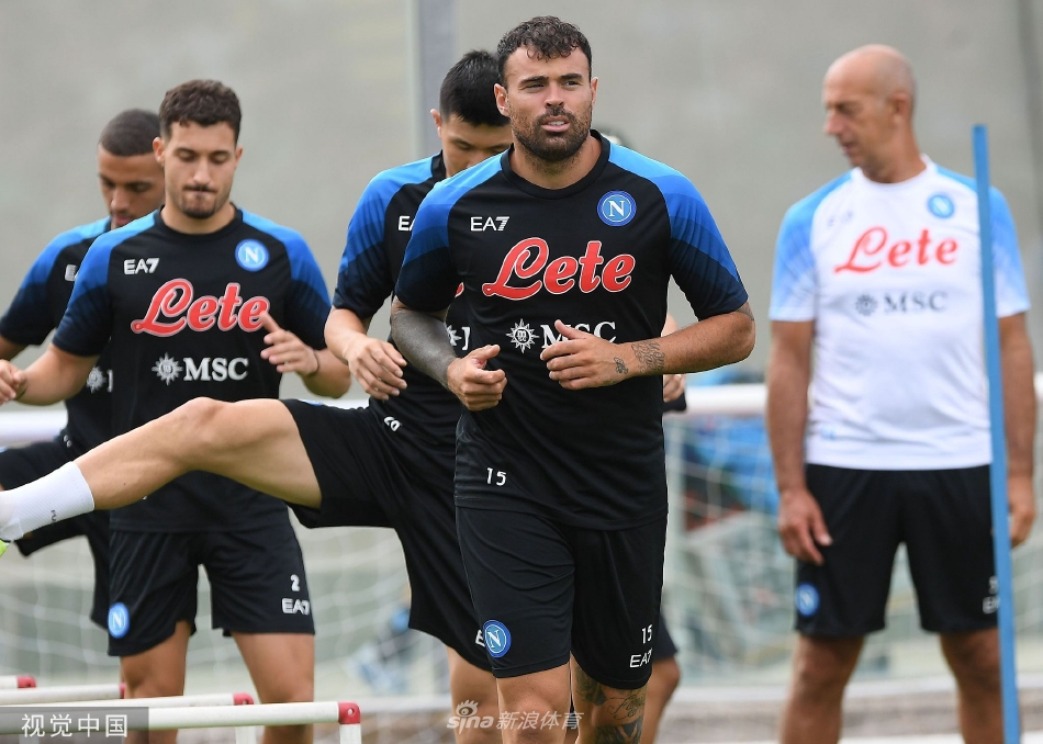 主教练斯帕莱蒂手持战术板，在训练场边神情专注地指挥球员跑位，进行细致的战术部署。