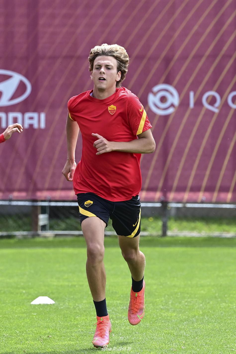 训练中一位罗马球员独自带球突破，他的身影与远处队友的剪影构成了备战日的动人画面。