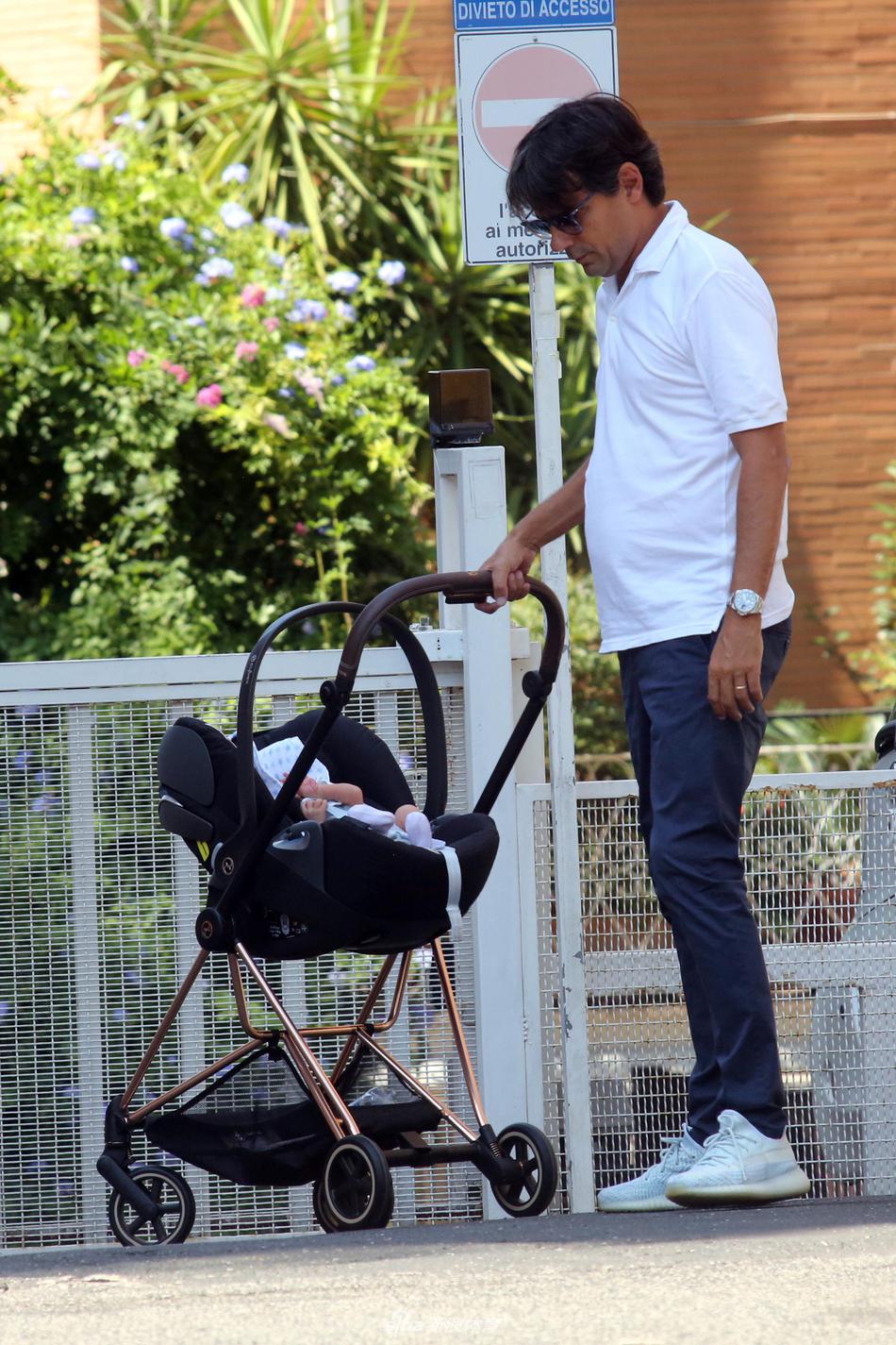 盖娅温柔地看向镜头，丈夫小因扎吉则在身后专注地推着婴儿车，绿荫掩映下的罗马街头，这一家人的身影成为最动人的风景。