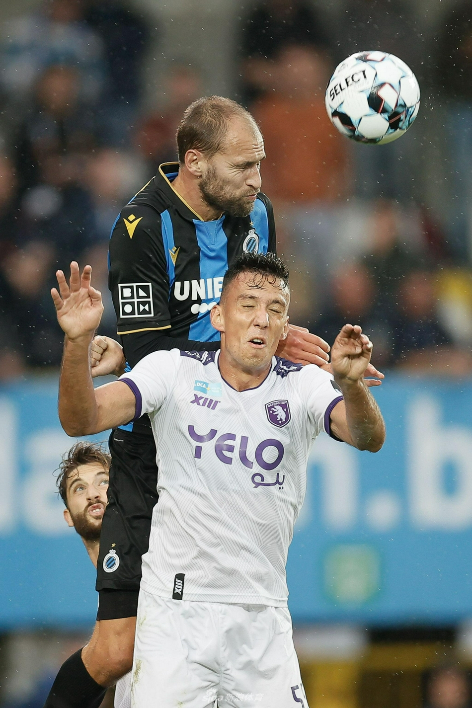 主裁判果断指向罚球点，布鲁日球员们围在一起紧张地商讨着战术，而比尔肖特的门将则在球门前张开双臂，试图通过肢体动作干扰对手，整个球场屏息凝视。