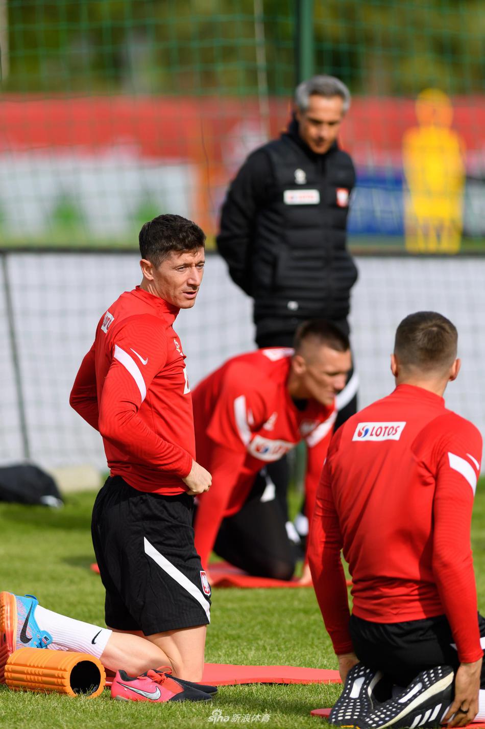 训练场边，波兰门将什琴斯尼全神贯注，双手稳稳接住皮球，眼神中透露出守护最后一道防线的坚定与专注。