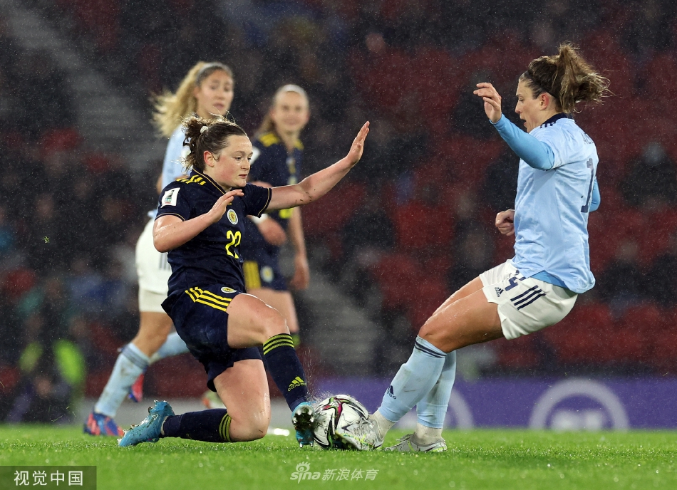 西班牙队球员在比赛中带球突破，两名苏格兰防守队员紧追不舍