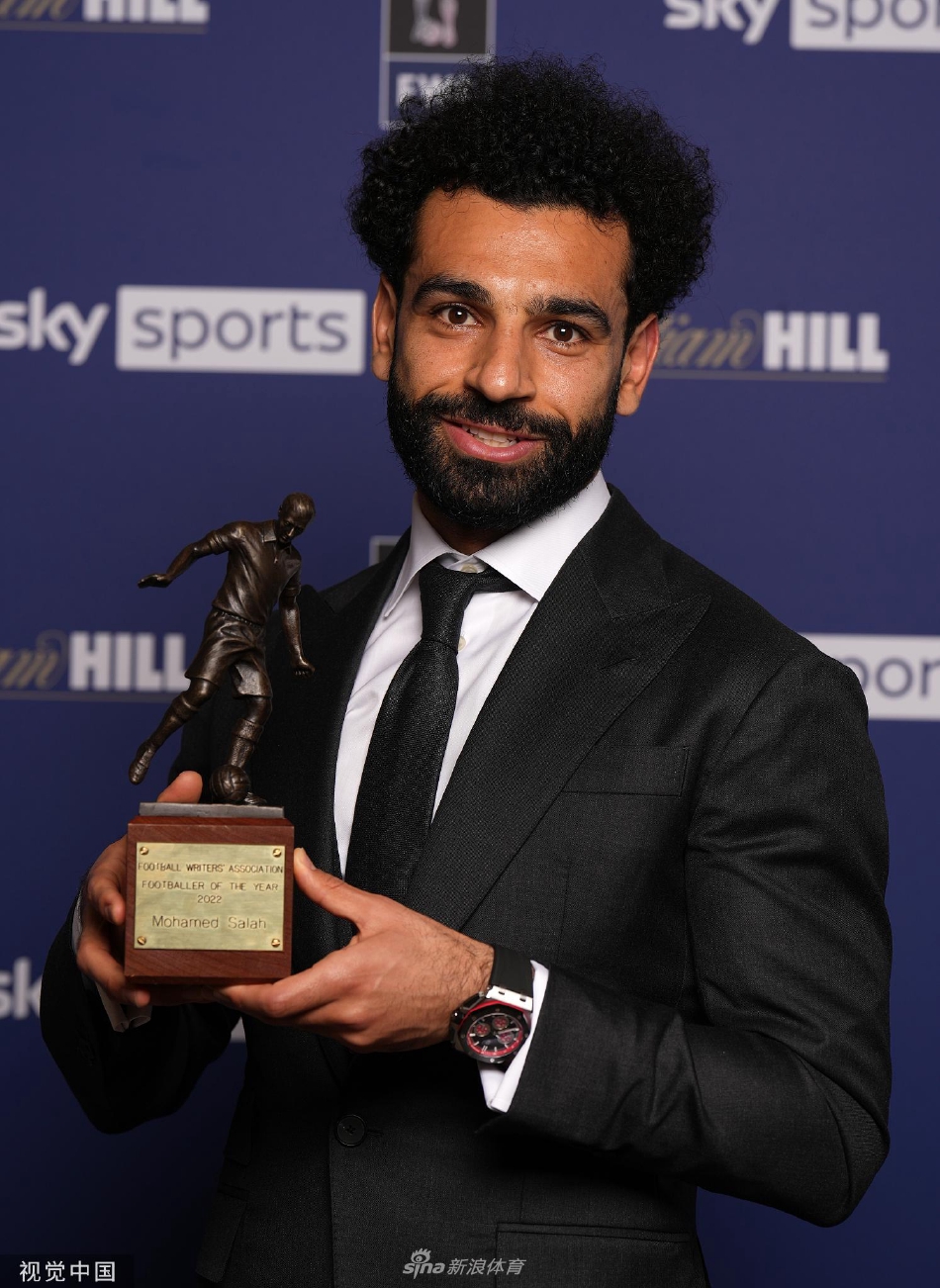 萨拉赫与英格兰足球记者协会年度最佳球员奖杯的单独合影，他深情凝视奖杯，仿佛在回顾一个赛季的拼搏与汗水。