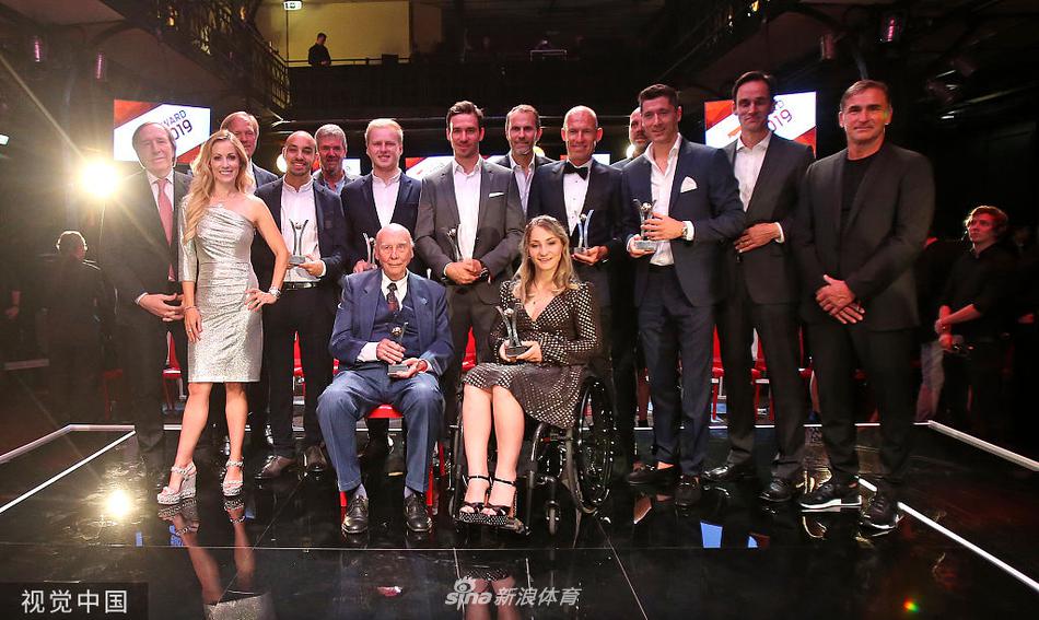 颁奖典礼现场罗本正与嘉宾握手交谈，他的光头在灯光下格外醒目，举手投足间尽显巨星风范与谦逊态度。