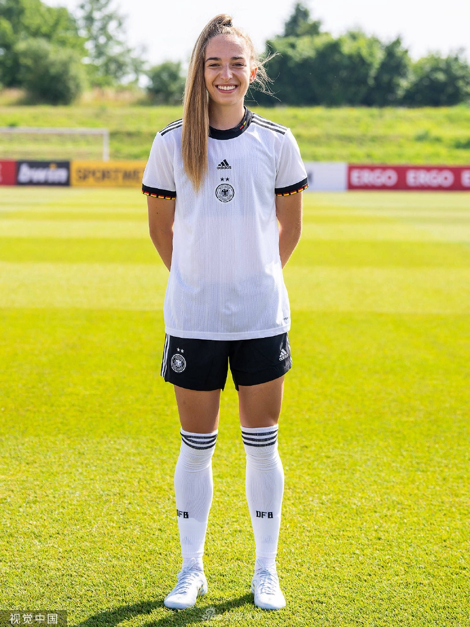 一位中场球员单独出镜，她单手托球倚靠墙面，姿态放松却目光如炬，深邃的眼神中透露出中场指挥官的智慧与掌控比赛的决心。