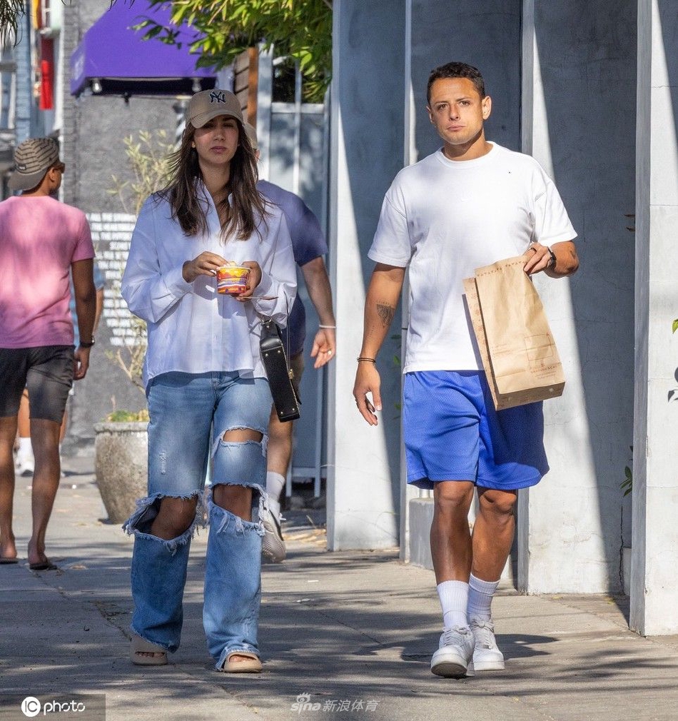 埃尔南德斯与超模女友手牵手并肩而行，他身穿简约休闲装，侧头倾听女友说话，眼神专注而温柔，画面充满日常的亲密感