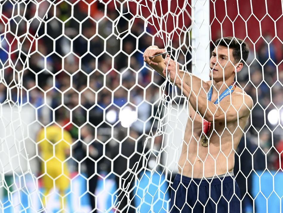 拄着拐杖的斯皮纳佐拉与队友们簇拥在金色的德劳内杯旁，他脸上绽放出孩子般灿烂的笑容。尽管无法在决赛中奔跑，但他依然是这支冠军之师中不可或缺的一员，拐杖旁的金杯见证了他的付出与荣耀。