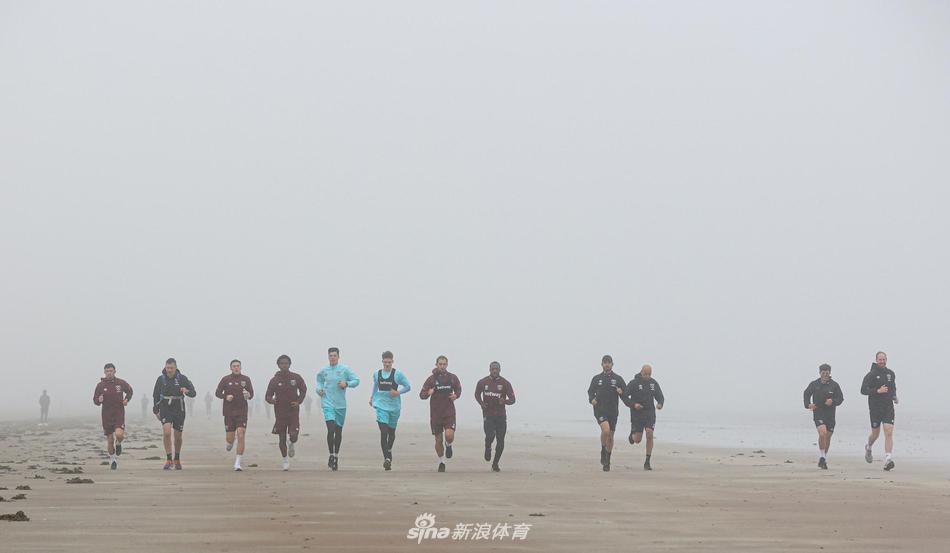 全体参训球员在大雾散去后的训练场上集结，围成一个圆圈进行最后的拉伸总结。背景的天空一半是散去的雾气，一半是显露的蔚蓝，象征着球队克服困难后迎来的明朗前景。