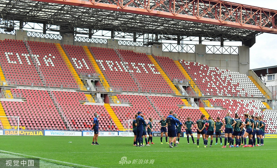 训练场上，一位意大利球员在教练注视下进行标志盘绕杆练习，专注的眼神仿佛能点燃整个球场