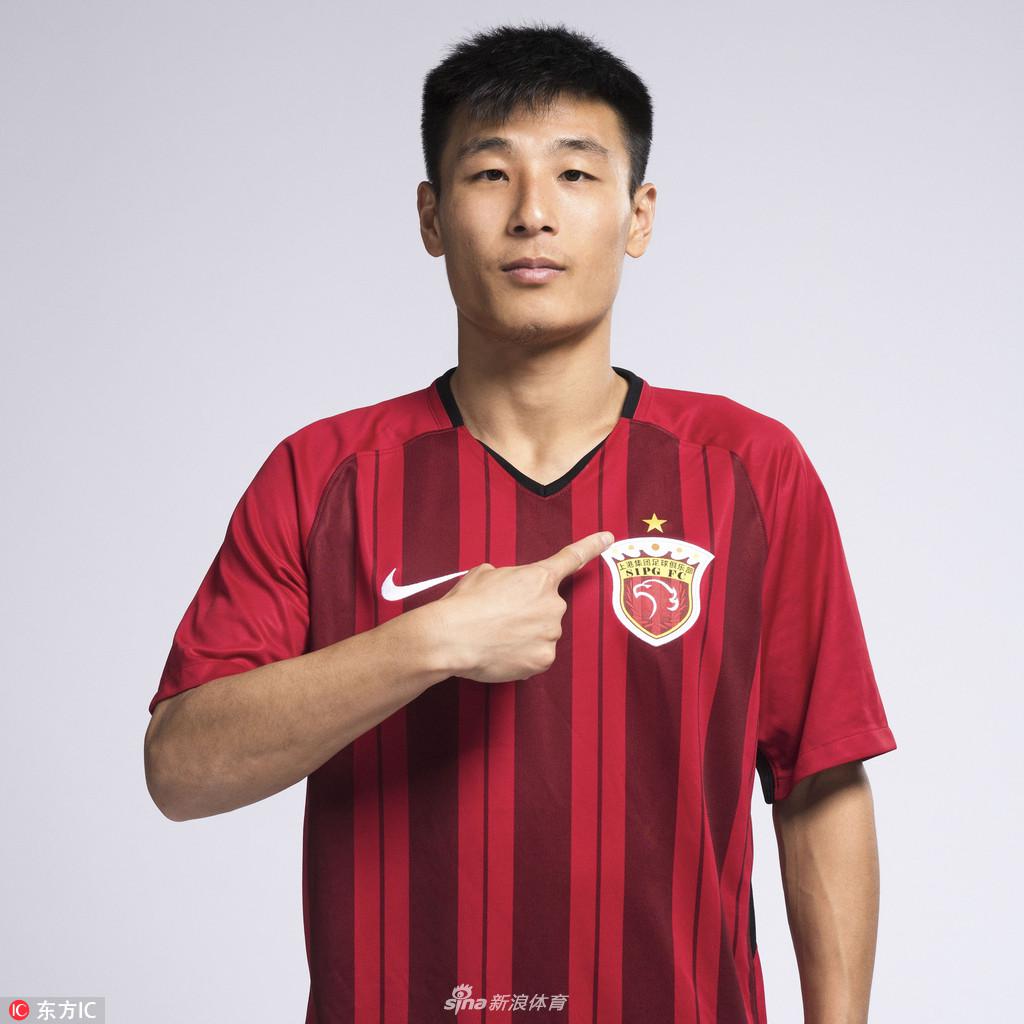 武磊身披绣有冠军金星的上港红色战袍,眼神坚毅,仿佛正凝望那座梦寐以求的火神杯,身后光影交错,映衬出荣耀时刻。