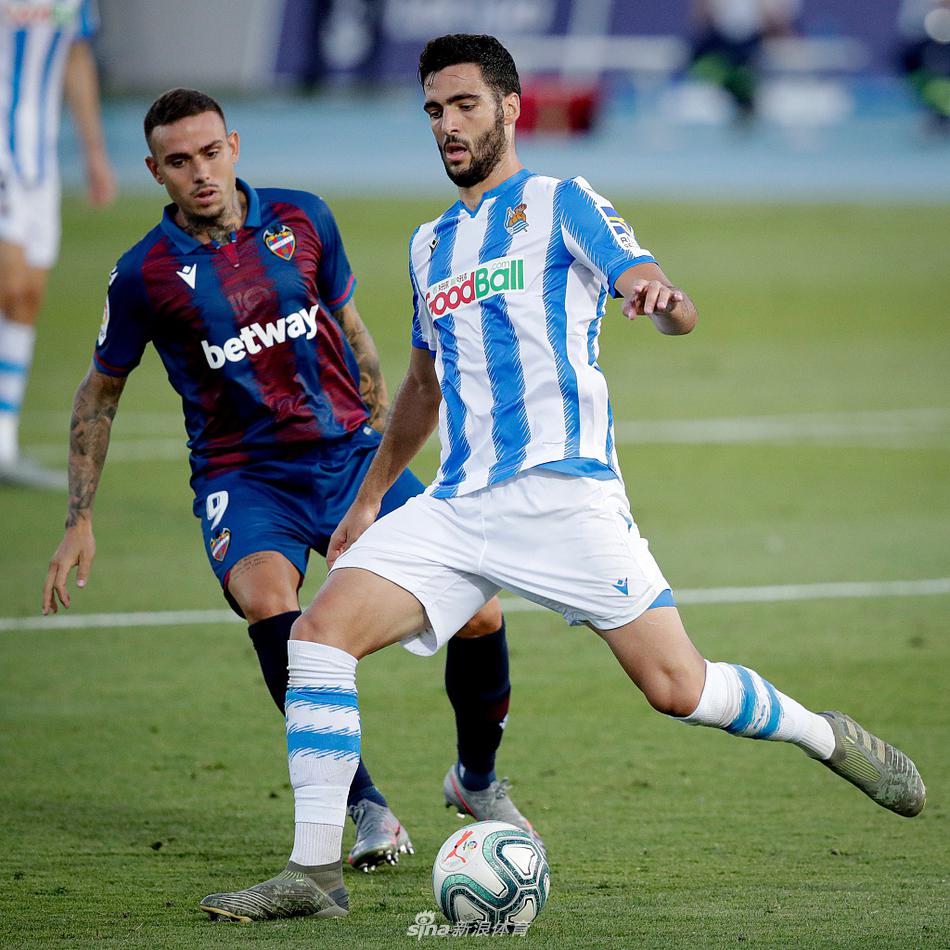 比赛用球静静地躺在球场中圈的开球点上，背景是看台上星星点点的球迷和空荡荡的座椅，象征着疫情复赛后独特的空场氛围，却也凝聚着场上球员全部的专注力。