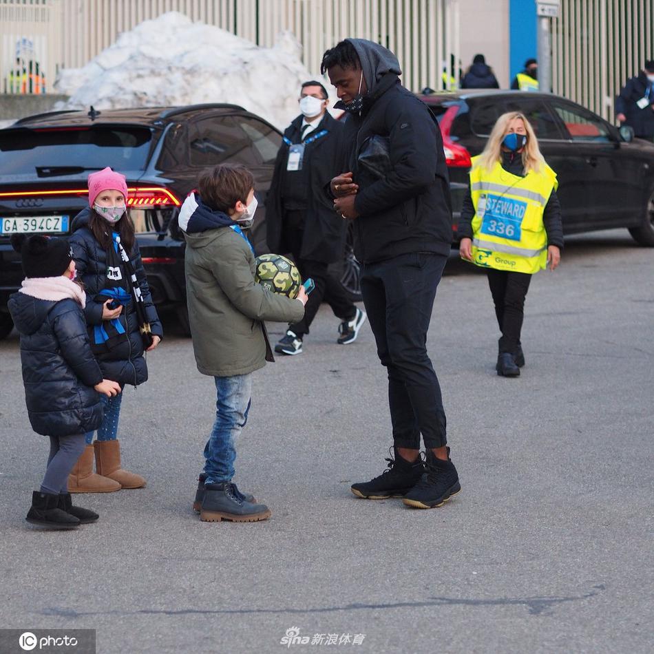 一位身穿拉齐奥球衣的小球迷翻过广告牌，他仰着稚嫩的脸庞，眼中闪烁着星辰，正举着笔等待偶像的签名。