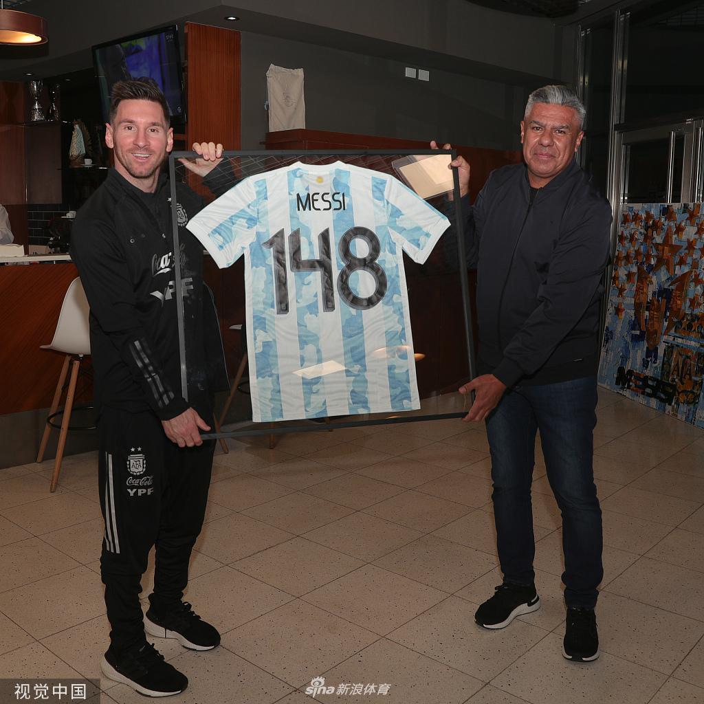 阿圭罗展示着自己的百场纪念球衣，背后的“100”号数字在灯光下熠熠生辉，他的脸上洋溢着自豪与喜悦。