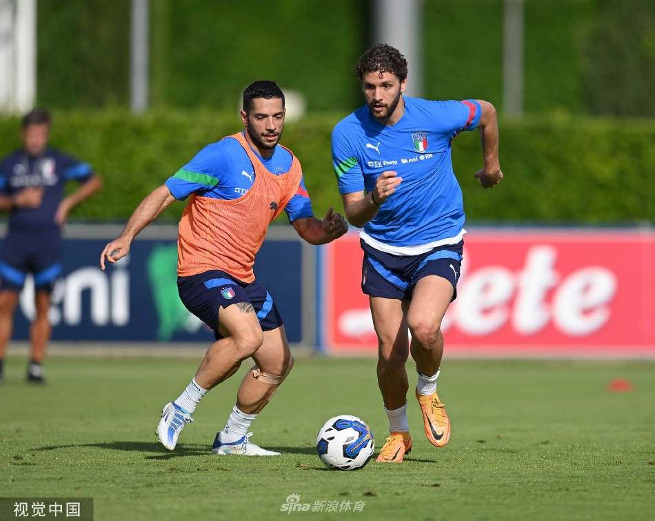 曼奇尼与教练组成员在场边密切交流，手持战术板，共同商讨比赛策略。