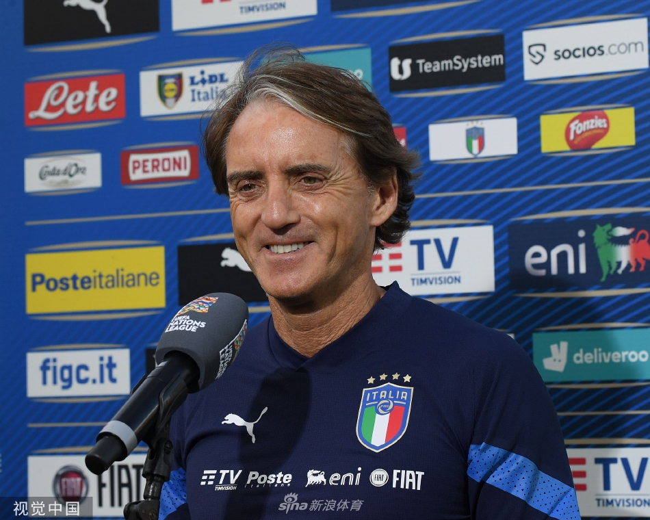 意大利主帅曼奇尼站在训练场边，双臂交叉于胸前，目光如炬地凝视着球场，深思中透露出重启球队的决心。