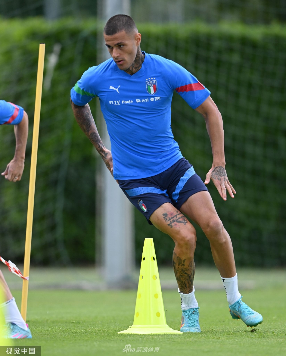 前锋因莫比利完成一脚劲射后望向球门方向，身体姿态保持着射门后的平衡与舒展，眼神中充满对进球的渴望，皮球如炮弹般划过训练场的空气。