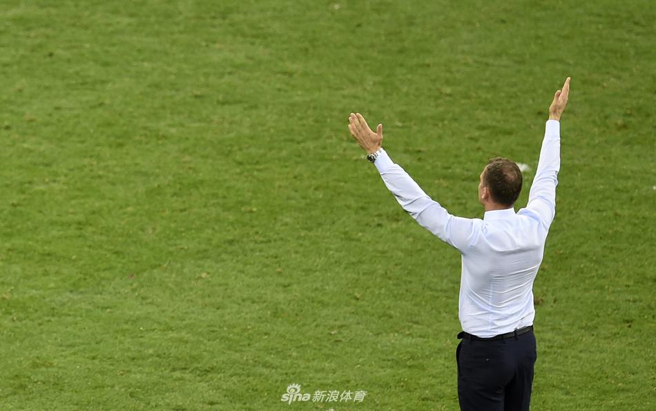 看台上的信仰：一名神情肃穆的乌克兰男球迷身披国旗，在球队表现不佳时依然眼神坚毅地望向球场方向，构成一幅充满信仰感的画面。