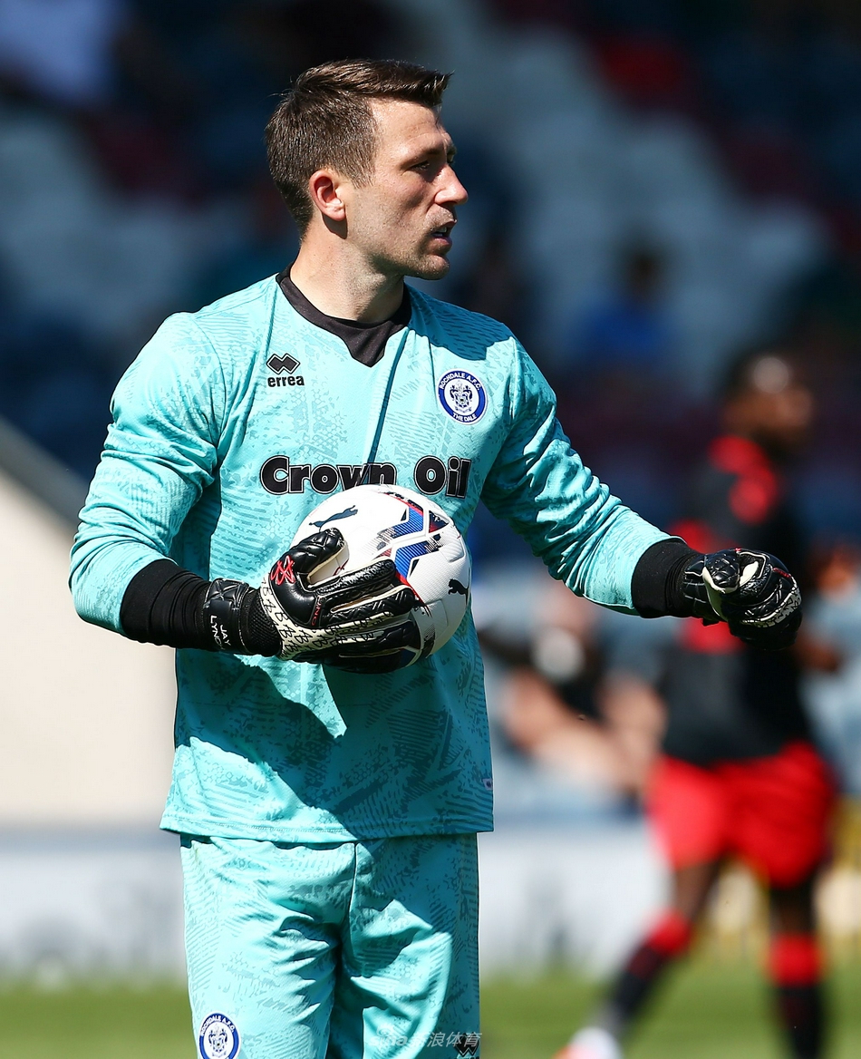 进球后的罗奇代尔球员们紧紧相拥，他们的脸上洋溢着开心的笑容，队长抬起手臂指向天空，与看台上欢呼的球迷分享这瞬间的喜悦。