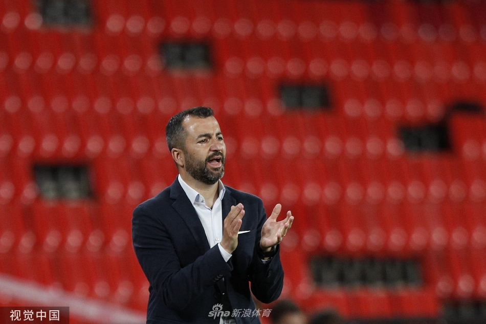 发布会现场灯光聚焦，马丁内斯身后巨型队徽熠熠生辉