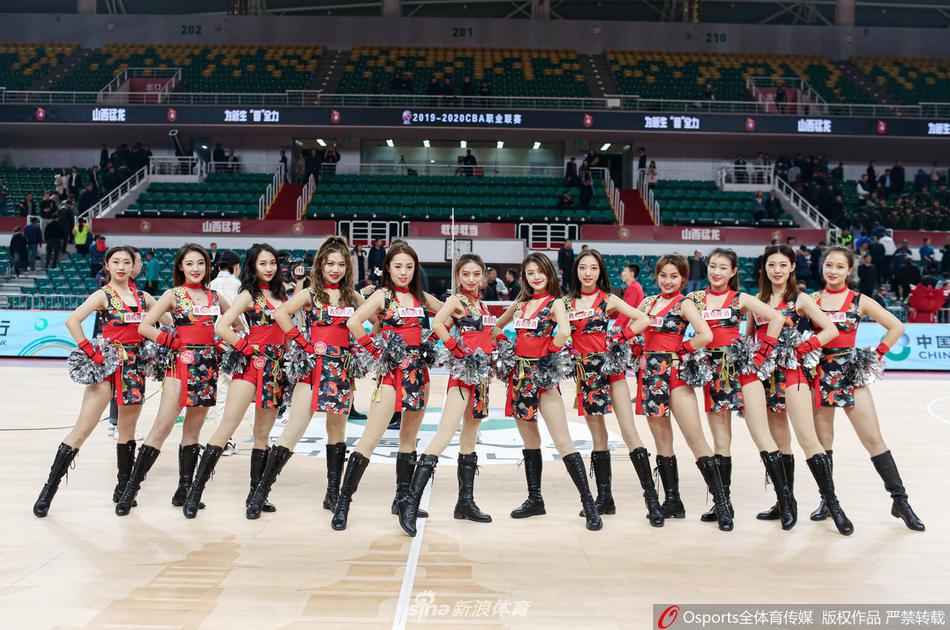 镜头捕捉到一位在聚光灯下起舞的篮球宝贝，她眼神坚定有力，每一个动作都充满了韵律感，展现出了极高的专业素养和舞台表现力。