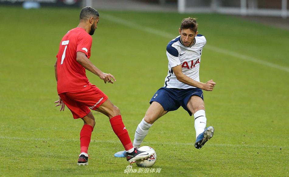 热刺U23球员在中场拿球转身，两名莱顿东方防守球员迅速形成包夹之势，三人之间的对抗充满力量感，脚下的足球成为争夺的焦点。