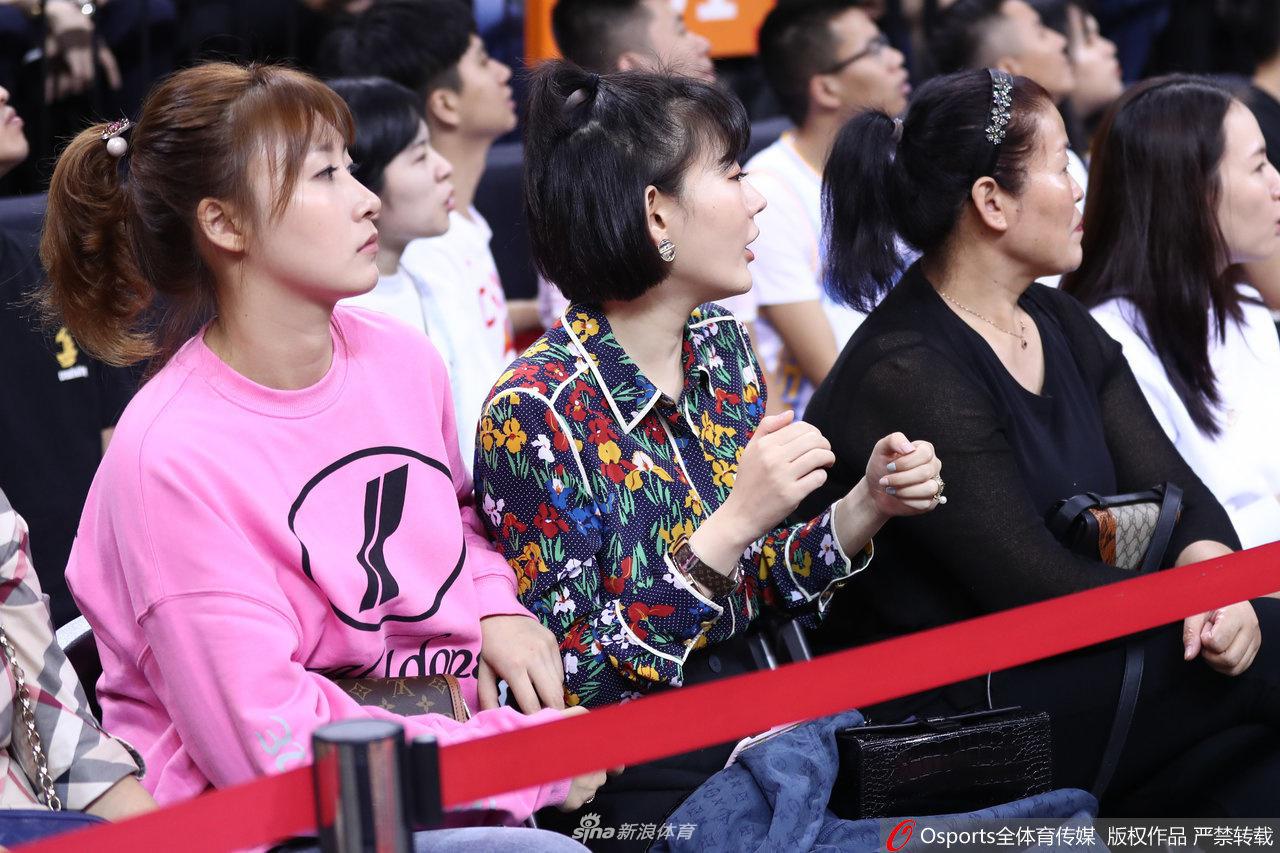 喧嚣的球场一角，一位女球迷安静地坐在座位上，眼神中流露出一丝对球队现状的担忧，紧锁的眉头让人感受到她对比赛的投入和对主队成绩的深深牵挂。