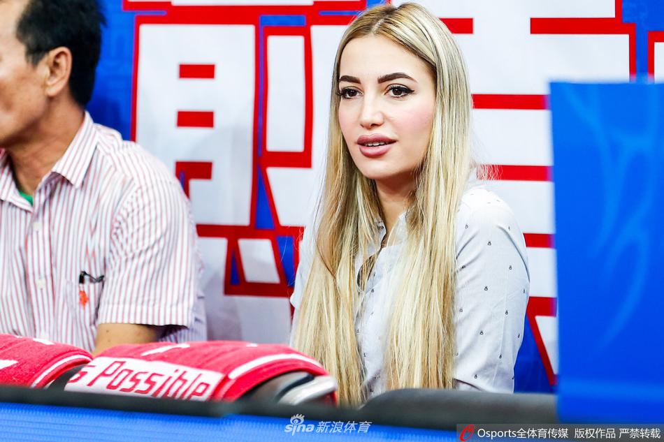 看台上，一位身着浅色衣服的福建美女球迷笑容灿烂，眉眼弯弯如新月，她的快乐感染了周围的每一个人，此刻她正和身边的朋友分享着比赛的精彩瞬间。