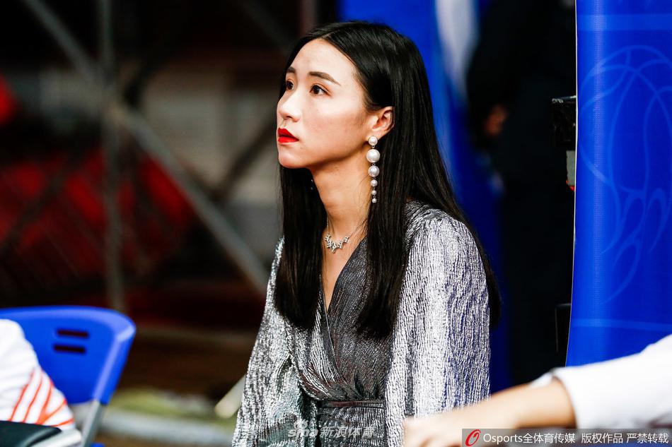 在晋江祖昌体育馆的耀眼灯光下，一位长发披肩的福建女球迷回眸凝视，眼神中充满了对主队胜利的渴望，仿佛她就是这个球场上的女神。