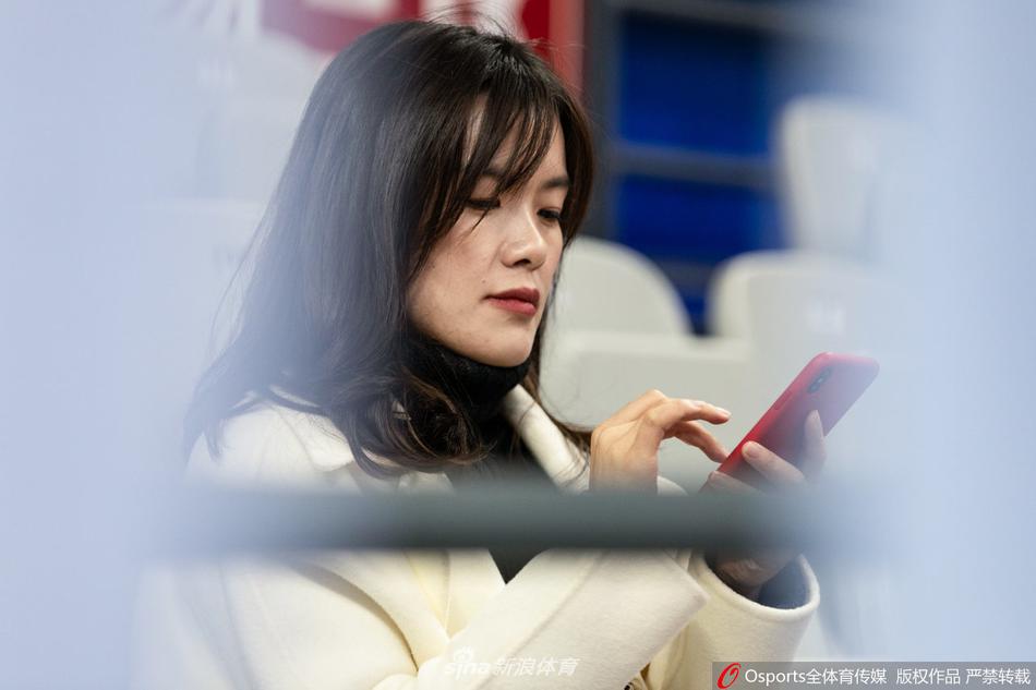 赛后，一位气质美女球迷在看台上整理衣物准备离场，背景是正在退场的观众，她的神情淡然，仿佛还沉浸在刚才那场跌宕起伏的比赛中，流连忘返。