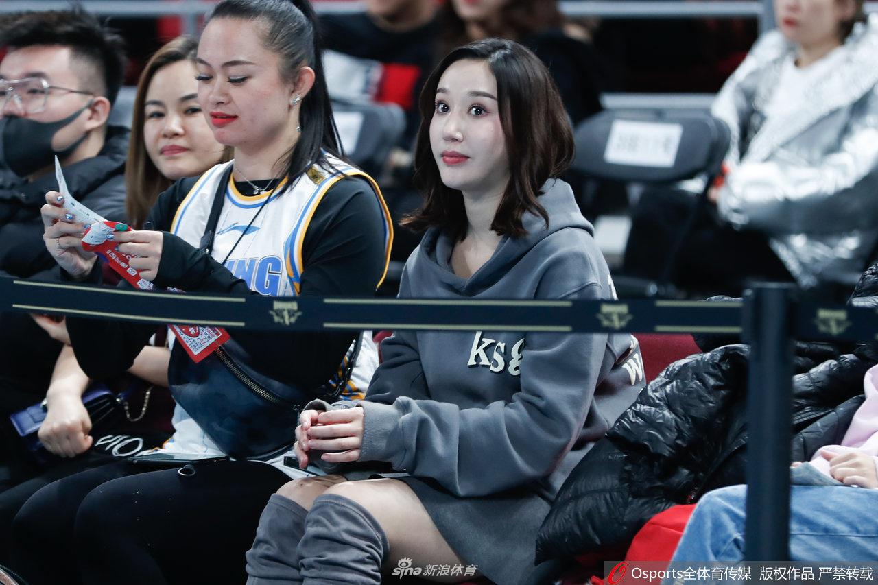 在新疆队一次成功的防守后,看台上几位女球迷激动地站起身来,其中一位披散着长发,身穿深色卫衣,正用力鼓掌,脸上绽放出灿烂而自豪的笑容。