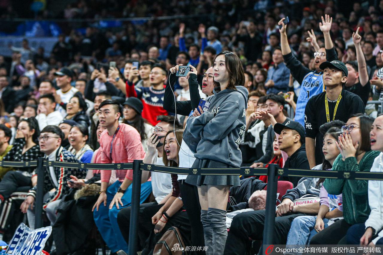 一位面容清秀的女球迷身穿厚厚的羽绒服,在五棵松体育馆的看台上,双手放在嘴边做喇叭状,眼神中满是焦急与期待,正用尽全力为场上拼搏的北京首钢队呐喊助威。