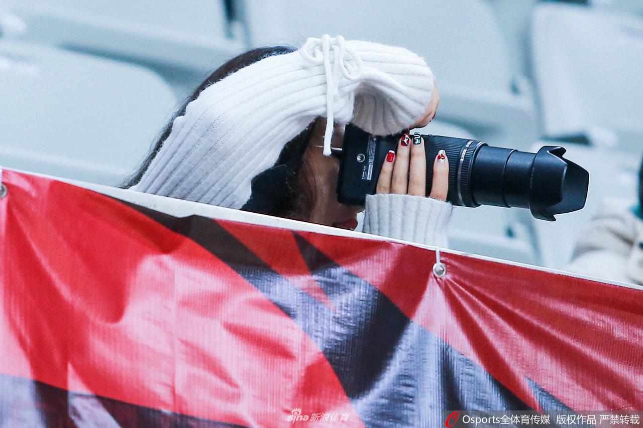 两位浙江美女球迷并肩而坐，眼神中透露着对比赛走势的专注，其中一位的红唇在球馆灯光下格外明艳，为紧张的赛事增添了一抹亮色。