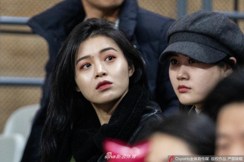 球场灯光的映照下，一位戴着时尚贝雷帽的俏皮女球迷微微侧身，她嘴角扬起的弧度如同浙江队开场时那波26比22的领先攻势一般自信而迷人，背景里模糊的座位恰好衬托出这份清晰的愉悦。