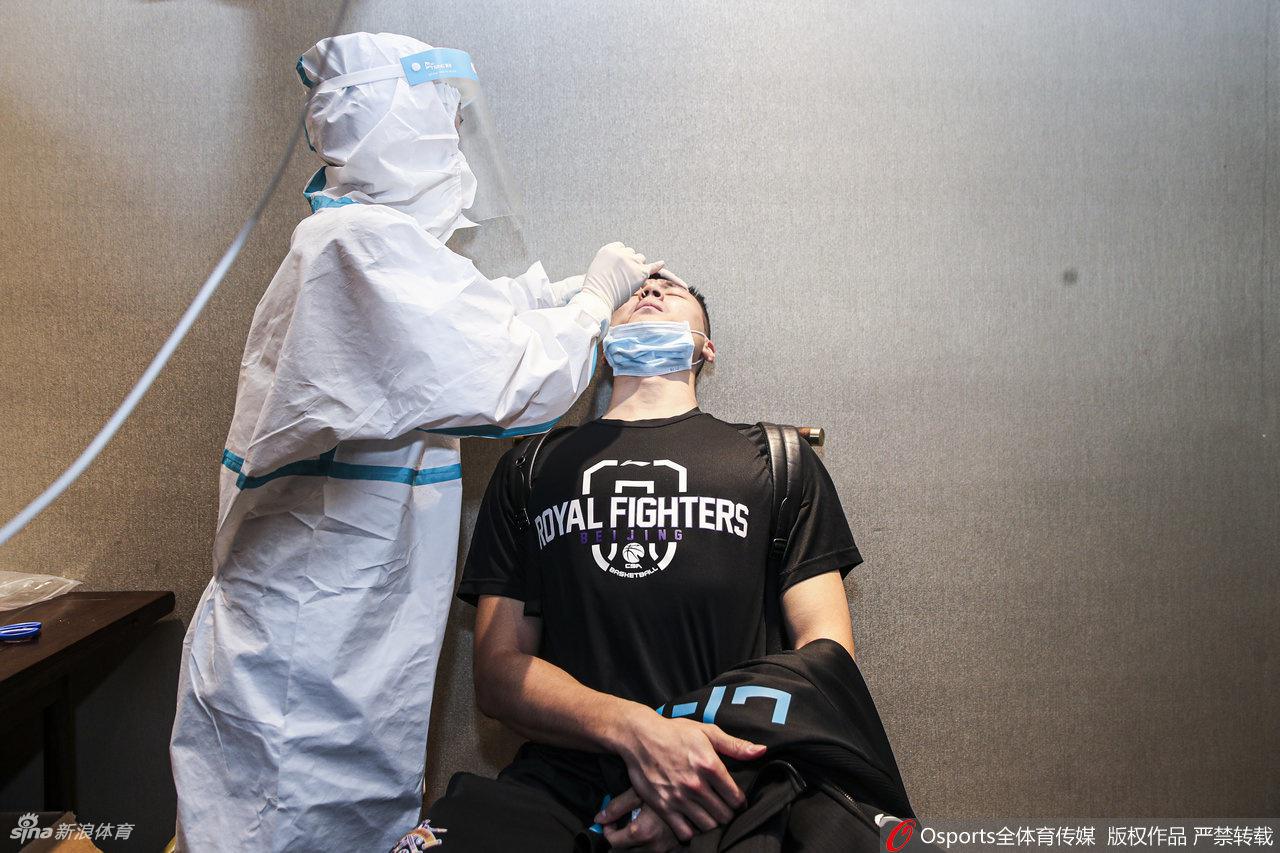 李根神情专注地配合医务人员进行核酸采样，昔日冠军锋线的脸上写满了对复出赛季的坚毅与期待。