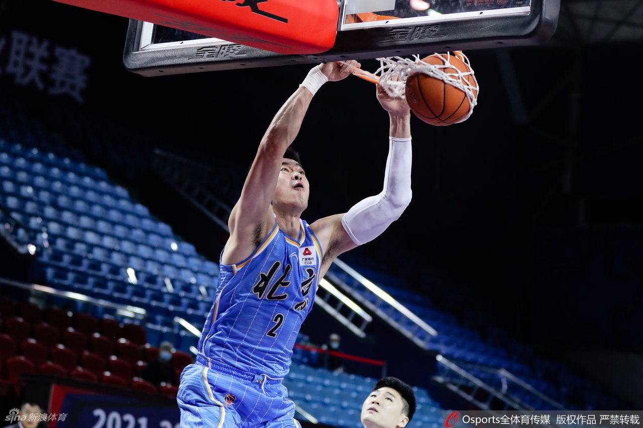 北京队球员们在暂停期间围成一圈，主帅正在战术板上布置下一阶段的攻防策略，队员们神情专注，充满了凝聚力。