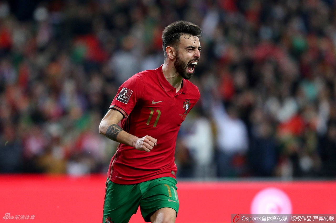 布鲁诺·费尔南德斯攻入第一球后张开双臂奔跑庆祝，背景中助攻的C罗正指向他并准备一同分享喜悦